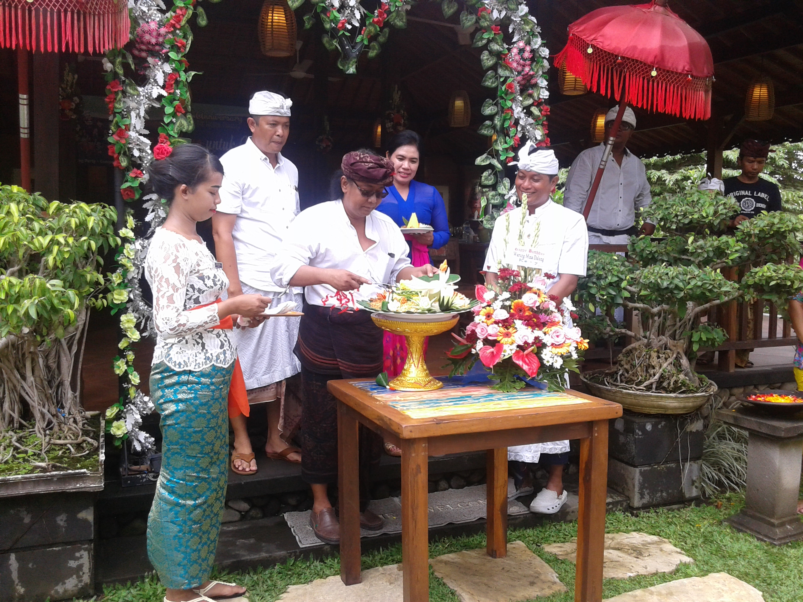 Owner Warung Mina Dalung Gusti Ngurah Agung Trisena Bratha memotong tumpeng didampingi Manager Operasional Wayan Astawa, Camat Kuta Utara dan Kepala Desa Dalung.